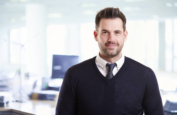 Portrait shot of handsome businessman wearing casual clothes while standing in the office.  - Foto, afbeelding