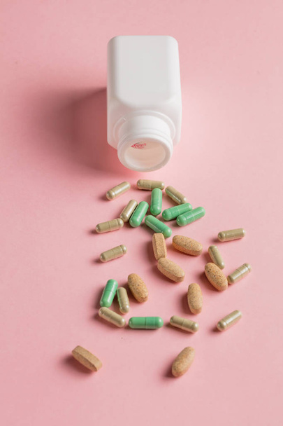 sprinkled capsules in open bottle - Photo, Image