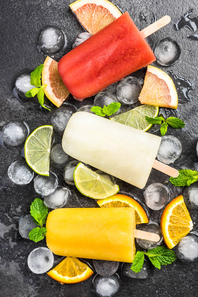 Natural juice homemade healthy popsicles over ice cubes - Photo, Image