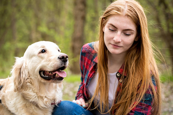 πορτρέτο ενός κοκκινομάλλη κορίτσι με ένα σκυλί - Φωτογραφία, εικόνα