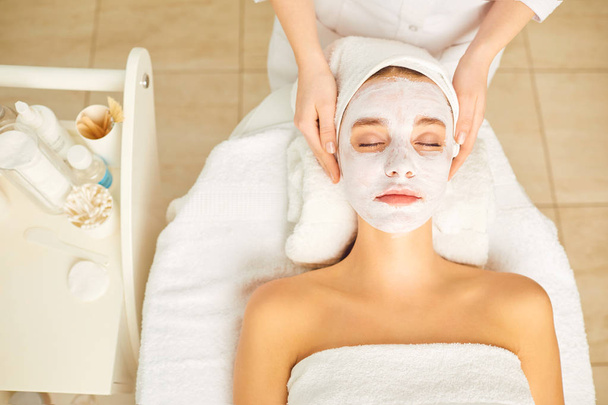 Woman in cosmetic mask lying down in the beauty salon. - Fotoğraf, Görsel