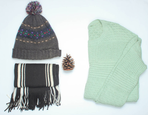 Zimowe ubrania i akcesoria. Sweter, szalik, kapelusz na białym tle. Płaskie la - Zdjęcie, obraz