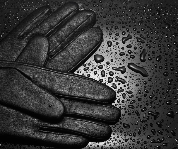Leather gloves close-up on a black background with water drops. fashion concep - 写真・画像