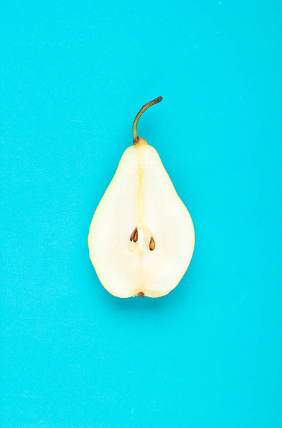 Ripe sliced pear on a blue background. Minimalis - Photo, image