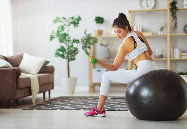 Młoda kobieta robi fitness i sportowe w domu    - Zdjęcie, obraz