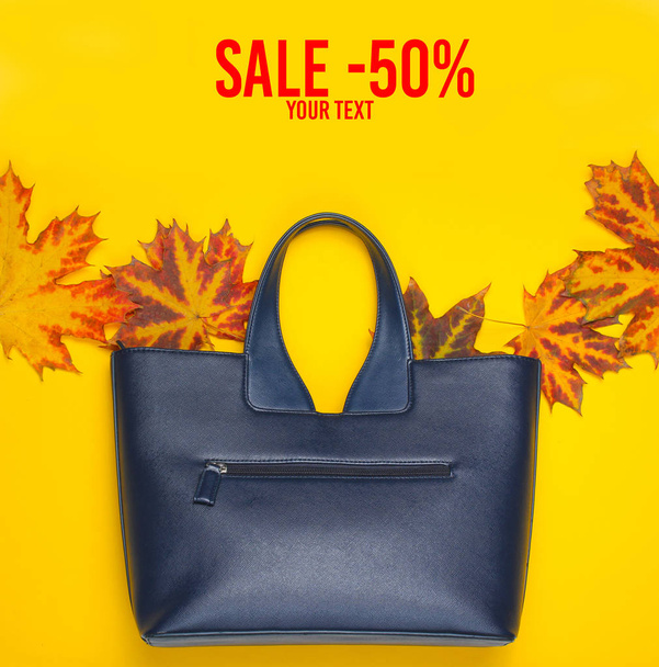 Autumn collection. Sale -50%. Leather bag of fallen autumn leaves on a yellow background. Seasonal accessories. Top view. Copy spac - Photo, Image