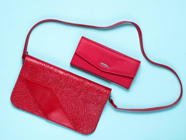 Bolso y billetera de cuero rojo estilo retro sobre fondo azul, vista superior
 - Foto, Imagen