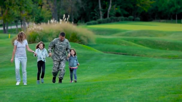 Αμερικανική οικογένεια με τον πατέρα μας στρατιώτη που παίζει στο γκαζόν του πάρκου. - Πλάνα, βίντεο