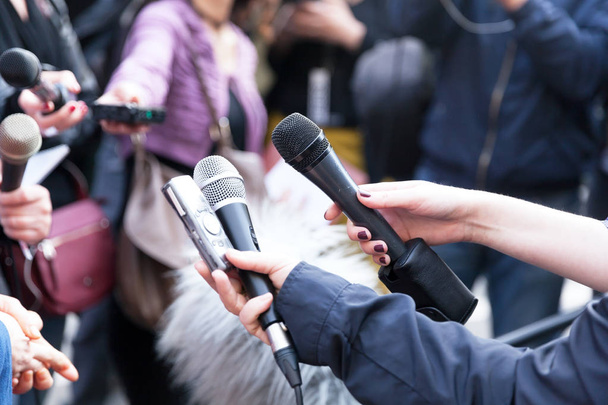 Jornalistas segurando microfones na conferência de imprensa
 - Foto, Imagem