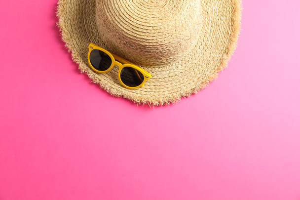 Strohhut mit Sonnenbrille auf farbigem Hintergrund, Platz für Text, T - Foto, Bild