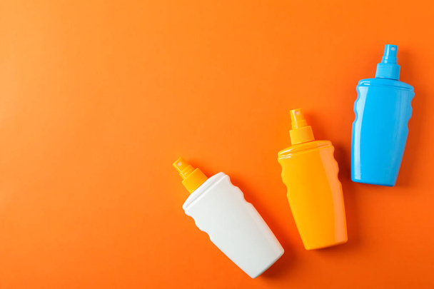 Flat lay composition with sunscreen sprays on color background.  - Photo, Image