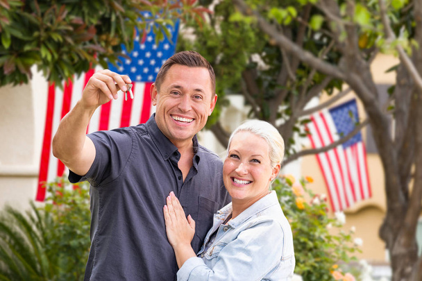 Happy Couple With New House Keys In Front of Houses with American Flags. - Valokuva, kuva