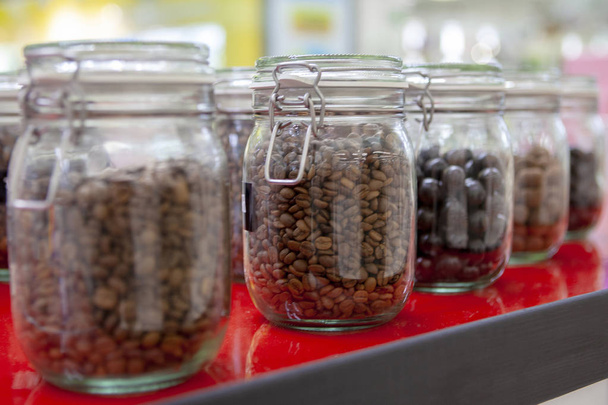 Coffee beans in glass jars on the cafe counter. - Photo, image