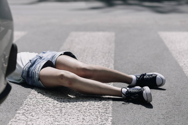 Teenage kid lying on the street after terrible car crash on pedestrian crossing - Фото, зображення
