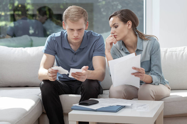 Νεαρό ζευγάρι κάνει χαρτιά μαζί, σχεδιάζει οικογενειακό προϋπολογισμό, τον υπολογισμό των εγχώριων δαπανών - Φωτογραφία, εικόνα