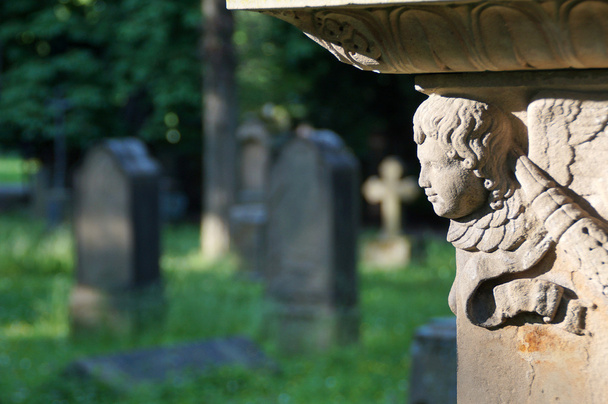 Egy gyönyörű angyal feje mosolyog a sötét temetőben - Fotó, kép
