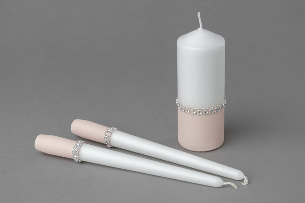 Three candles decorated with cloth in cream color. - Fotó, kép