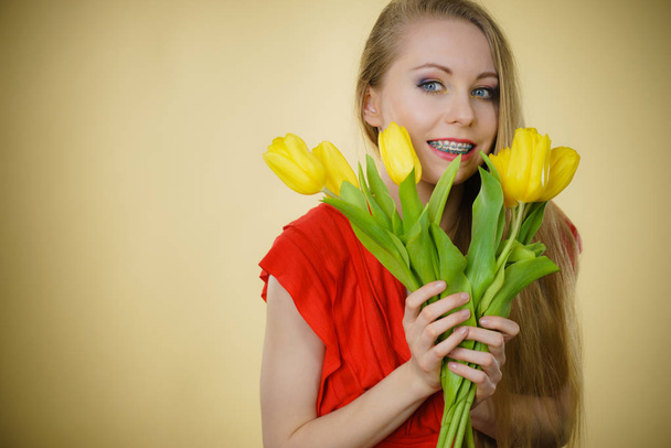 Mooie vrouw met gele tulpen bos - Foto, afbeelding