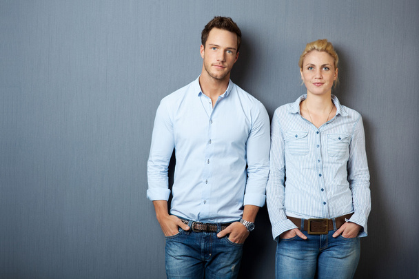 Portrait Of Serious Couple Against Gray Background - Photo, Image