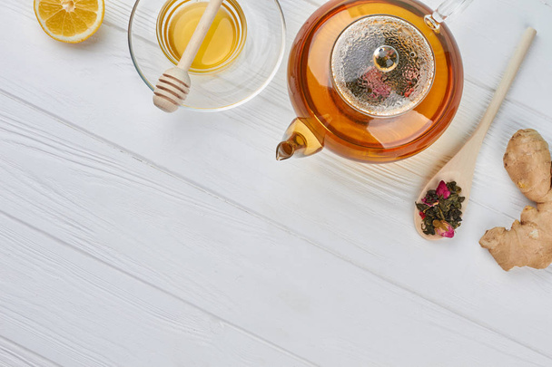 Teekanne mit Honig und Zitrone auf Holztisch. - Foto, Bild