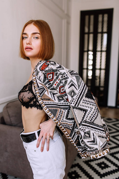 Beautiful sweet girl professionally posing on camera. Golden stylish model with short red hair, plump lips, casual clothing, costume, outfit, bra. Model test, clothing advertising - Zdjęcie, obraz