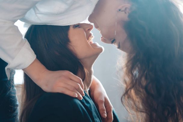 Close up jovem mulher pensativa beijando mulher em casa
 - Foto, Imagem