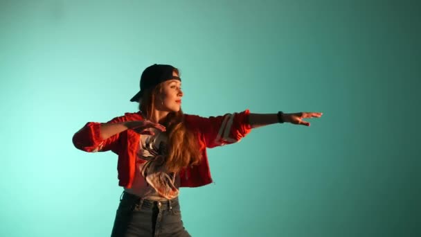 young beautiful girl in a baseball cap dancing hip hop, street dancing in the studio on a green background, isolated - Footage, Video