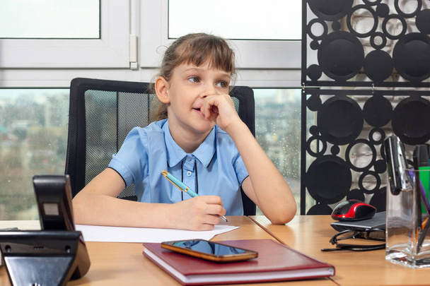 Восьмирічна дівчинка задумана за столом в офісі
 - Фото, зображення