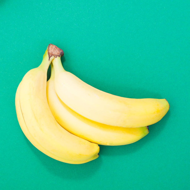 mooie bananen op een groene achtergrond kwadraat beeld - Foto, afbeelding