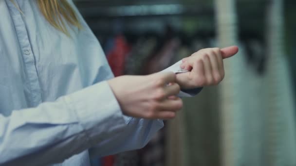 Vrouw knoopt mouwen van wit shirt dicht - Video