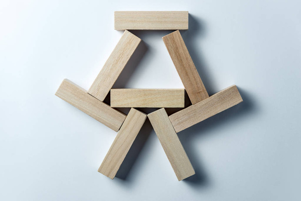 abstrakte geometrische Figur aus Holzwürfeln auf unebenem weißem Hintergrund. horizontaler Rahmen - Foto, Bild