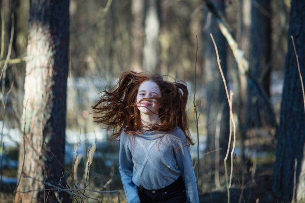 Carino teen ragazza con i capelli rossi fuoco in posa nel parco di pini per un servizio fotografico
. - Foto, immagini