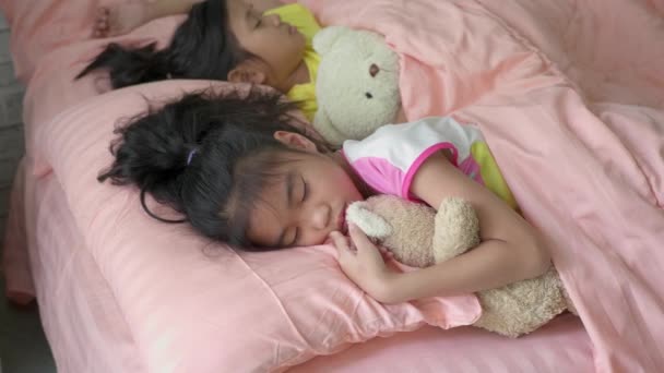 ベッドの上で寝ているアジアの女の子. - 映像、動画