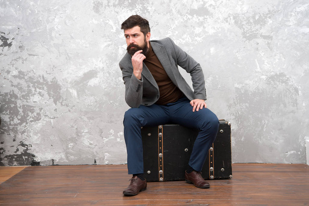 Relaxing after long trip. male fashion look. business trip adventure. trendy businessman with luxuty suitcase for traveling. grunge background. bearded man with travel bag. bag shop - Photo, image