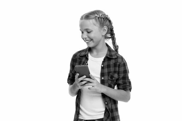 Examining her brand phone gadget. Mobile phone dependence. Girl cute small child smiling to phone screen. Internet surfing and social networks. Mobile phone and internet addiction or obsession - Photo, Image
