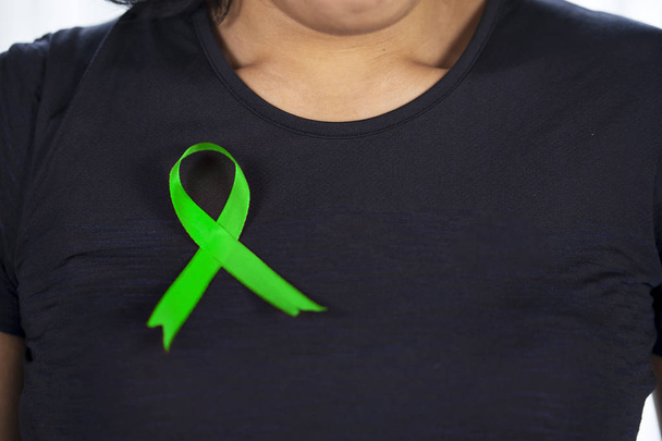 Kobieta z czarnymi ubraniami i zieloną wstążką wapienną - Zdjęcie, obraz