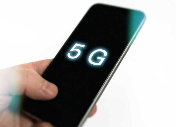 5g技術、5gのコンセプトを持つ携帯電話を使用して手、携帯電話のスマートフォンと白でインターネット - 写真・画像