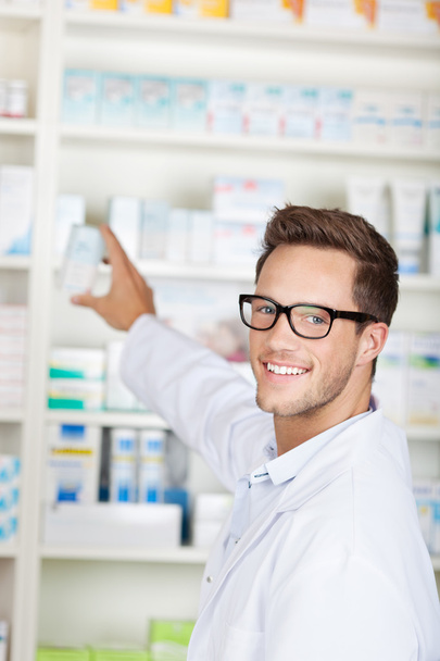 Male Pharmacist With Drug Package At Drugstore - Foto, immagini