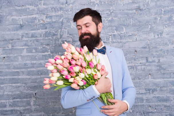Womens day. Spring beauty. Flower for March 8. Spring gift. Bearded man with flowers. Bearded man with tulip bouquet. Love date. international holiday. happy bearded man. bearded florist. man in love - Foto, Bild