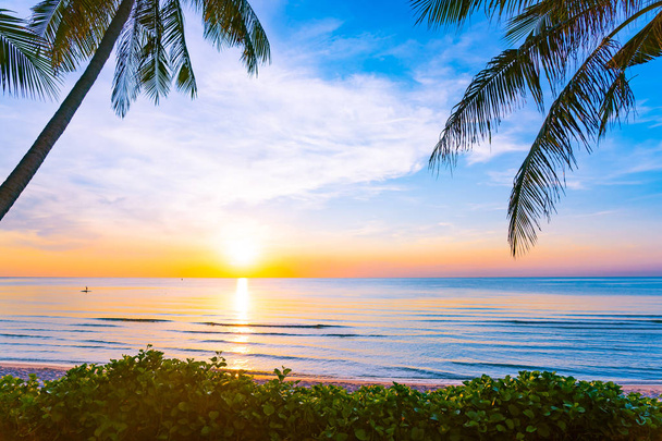 schöne Naturlandschaft im Freien mit Meer und Strand mit Kokospalmen bei Sonnenaufgang oder Sonnenuntergang für Freizeit und Urlaub - Foto, Bild