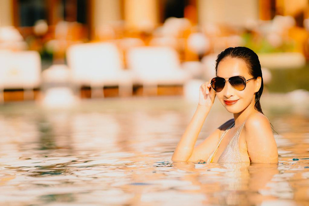 Portret mooie jonge Aziatische vrouw glimlach gelukkig ontspannen rond zwembad in Hotel Resort voor vakantie reizen en vakanties concept - Foto, afbeelding