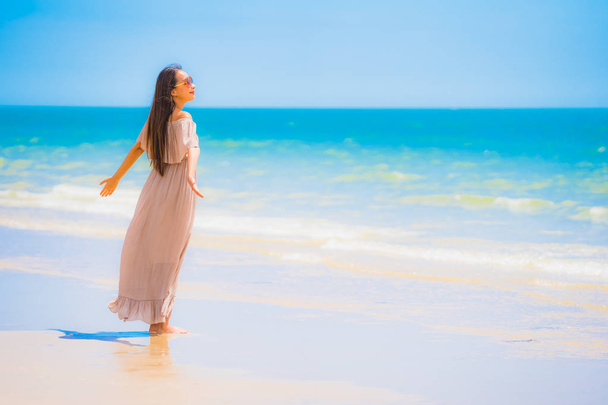 ポートレート美しい若いアジアの女性は、レジャー休暇のための熱帯屋外自然ビーチ海で幸せな散歩を笑顔 - 写真・画像