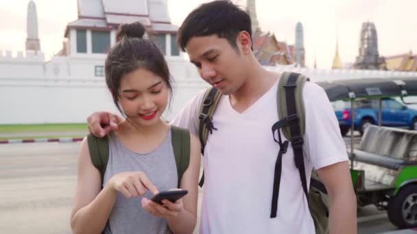 Slow Motion-reiziger Aziatische paar richting op locatie kaart in Bangkok, Thailand, lieve paar met behulp van mobiele telefoon op zoek kaart terwijl het doorbrengen van vakantie reis in zonsondergang. Lifestyle paar reizen concept. - Video