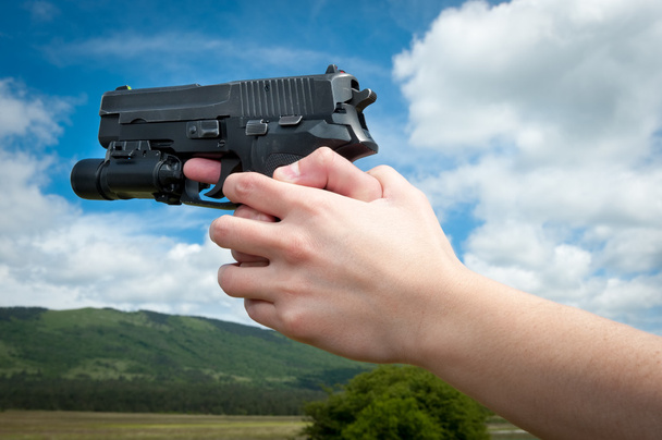 kobiety ręka trzyma pistolet, na białym tle - Zdjęcie, obraz