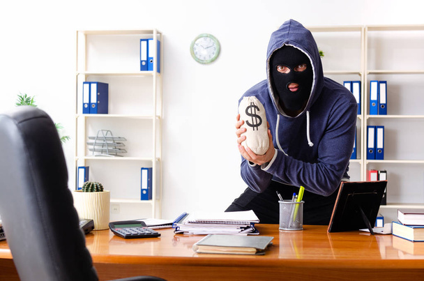 Hombre ladrón en pasamontañas en la oficina  - Foto, imagen