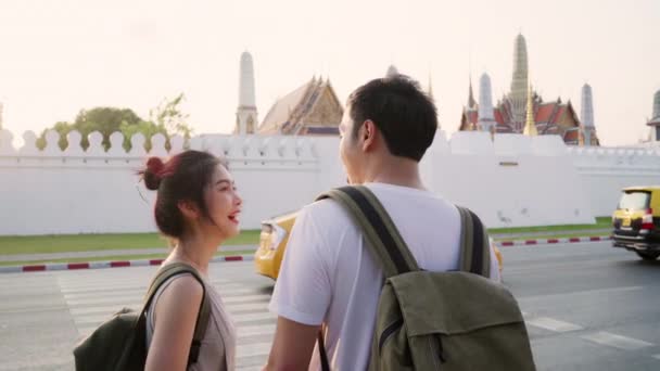Traveler Asian couple traveling and walking in Bangkok, Thailand, sweet Asia couple feeling happy spending sweet time in holiday trip in sunset. Lifestyle couple travel in city concept. - Footage, Video