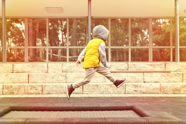 Happy boy jumping high on trampoline in the park - Φωτογραφία, εικόνα