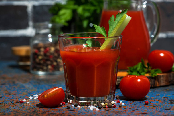 fresh tomato juice with salt and celery on dark table - Photo, image