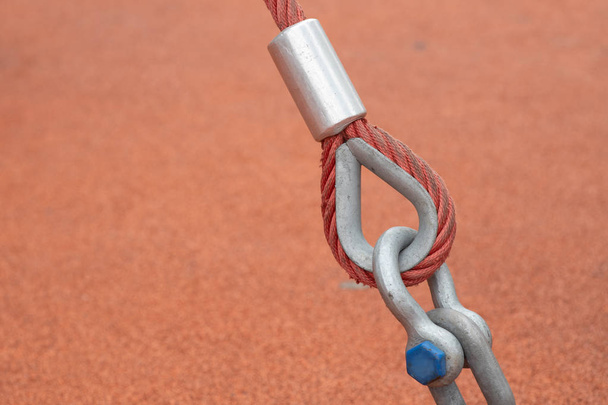 Fastening textile rope with a crimp to the metal loop. Tross with aluminum crimp clutch attached to a steel loop. Tensioned sling attached to a metal loop. - Foto, afbeelding