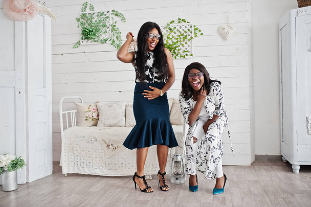 Two african woman friends wear on eyeglasses posed indoor white  - Фото, зображення